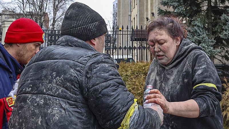 Mensen helpen een gewonde vrouw na de raketaanval