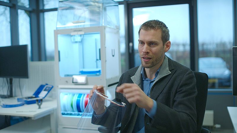 Erik de Bruin met een 3D-geprinte spatkap