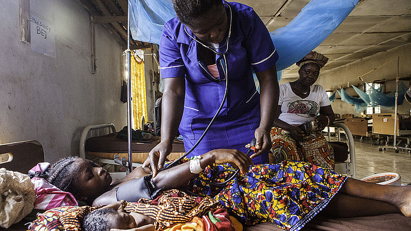 Verpleegster neemt hartslag op bij patiënt in ziekenhuis in Sierre Leone